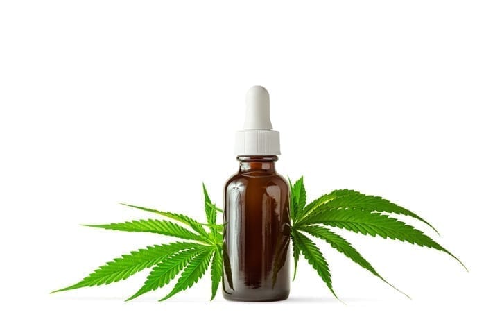 Glass Bottle of CBD or THC Oil with Hemp or Medical Cannabis Plant Leaves Isolated on White Background